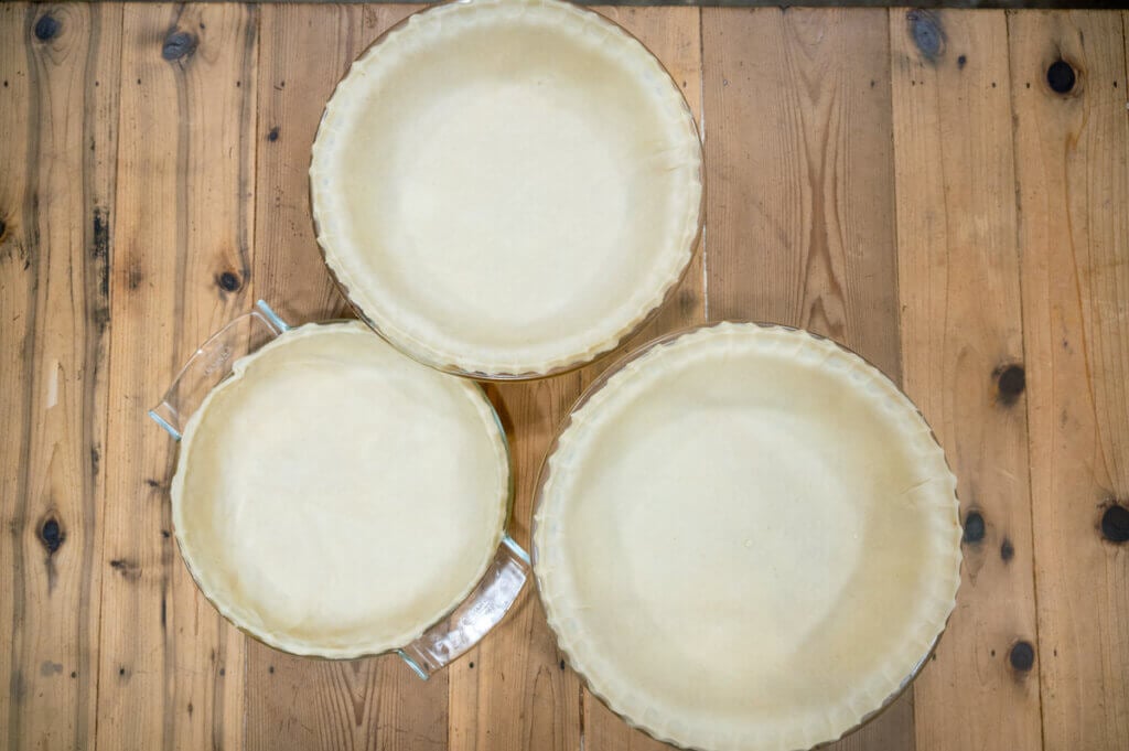 Birdseye view of three unbaked pie shells.