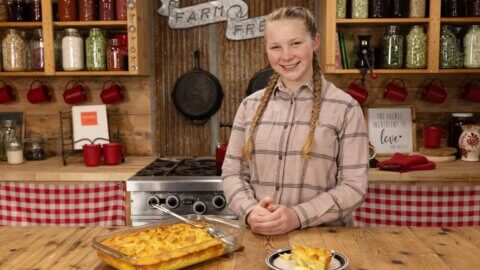 A girl standing in the kitchen with a French toast souffle recipe.