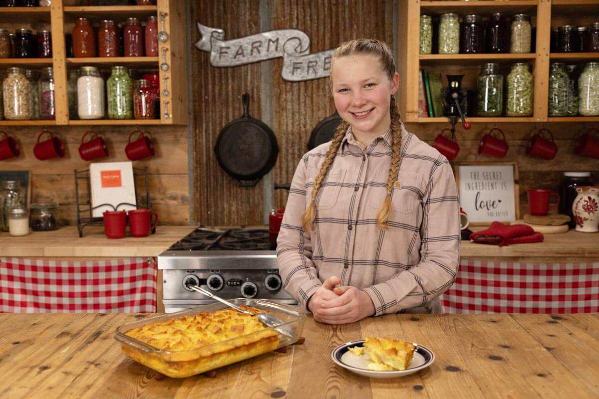 A girl standing in the kitchen with a French toast souffle recipe.