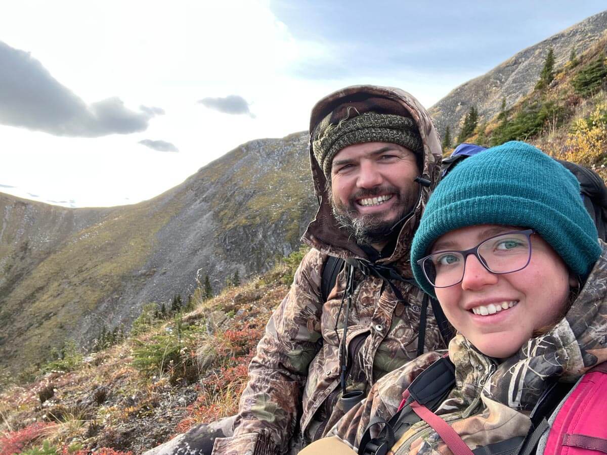 A father and daughter hunting on a hillside.