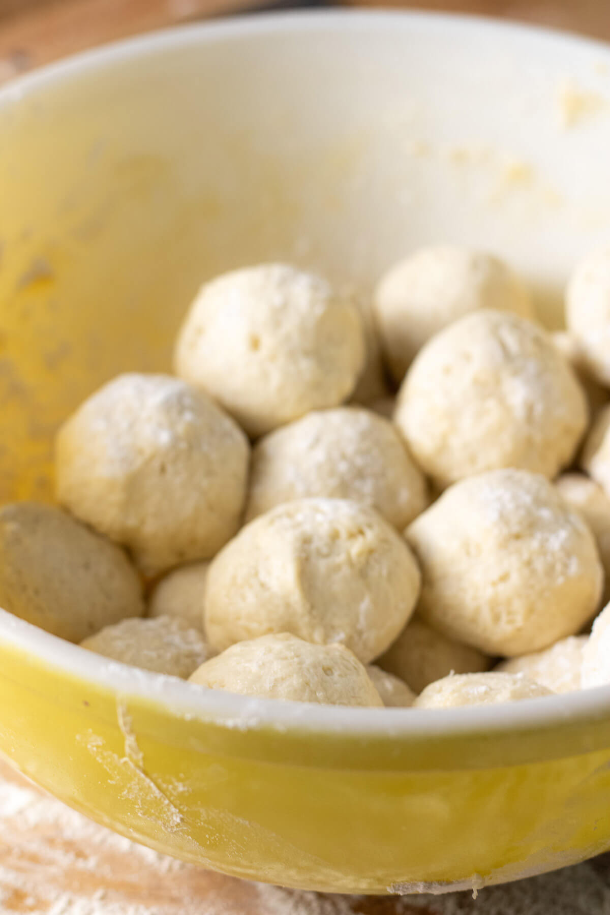 Sourdough discard tortilla dough divided into balls resting in a bowl.