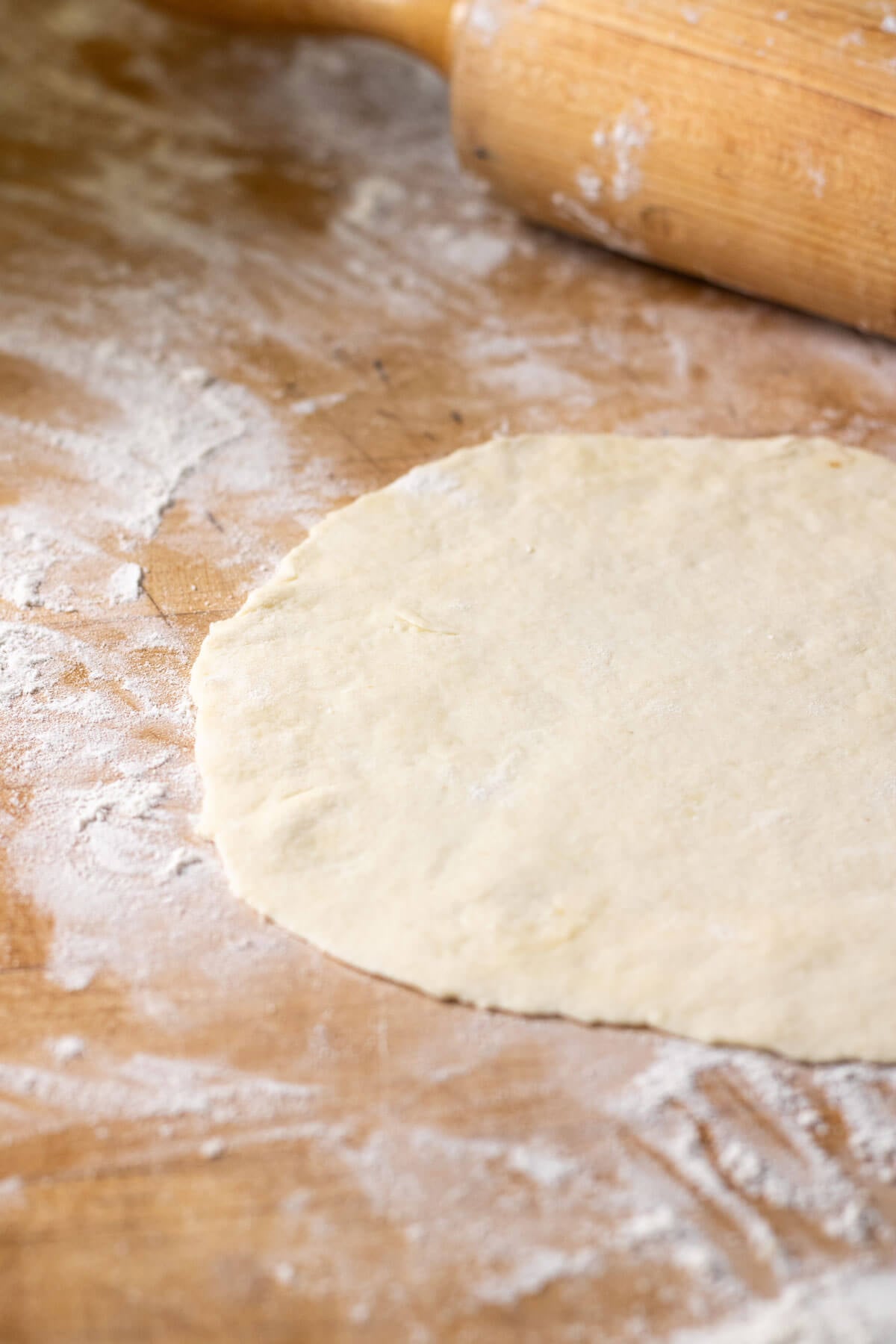 Sourdough discard tortilla rolled out on a floured surface prior to cooking.