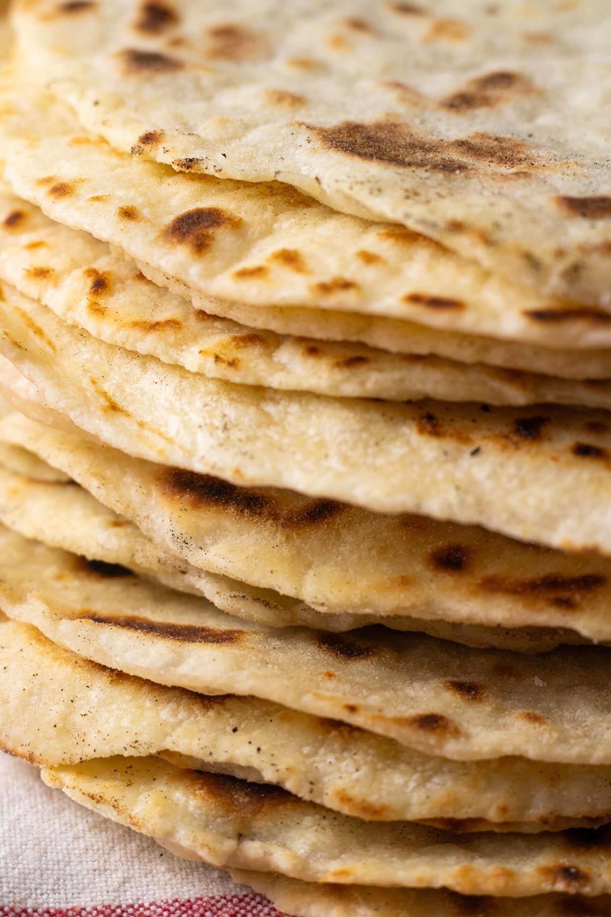 A close up shot of a stack of sourdough discard tortillas to show texture.