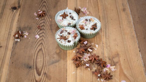 DIY Firestarter arranged with dried star anise, cloves, and flower petals on a wooden countertop.
