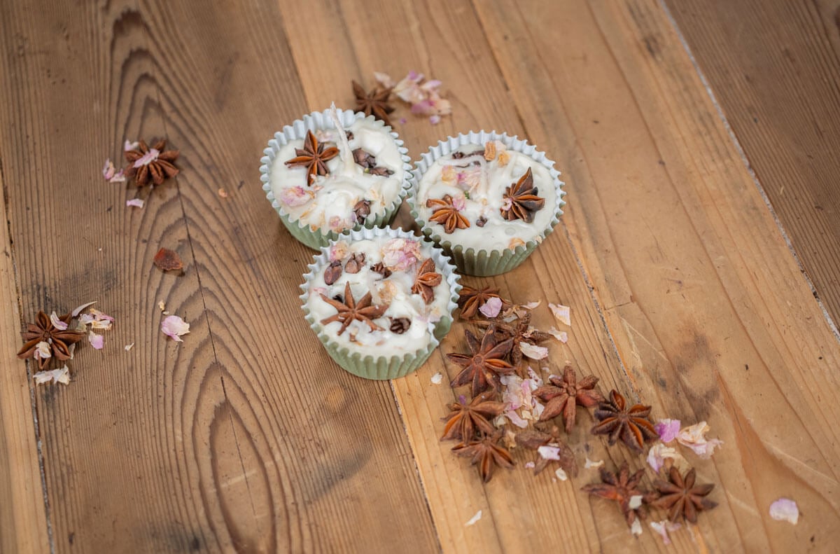 DIY Firestarter arranged with dried star anise, cloves, and flower petals on a wooden countertop.
