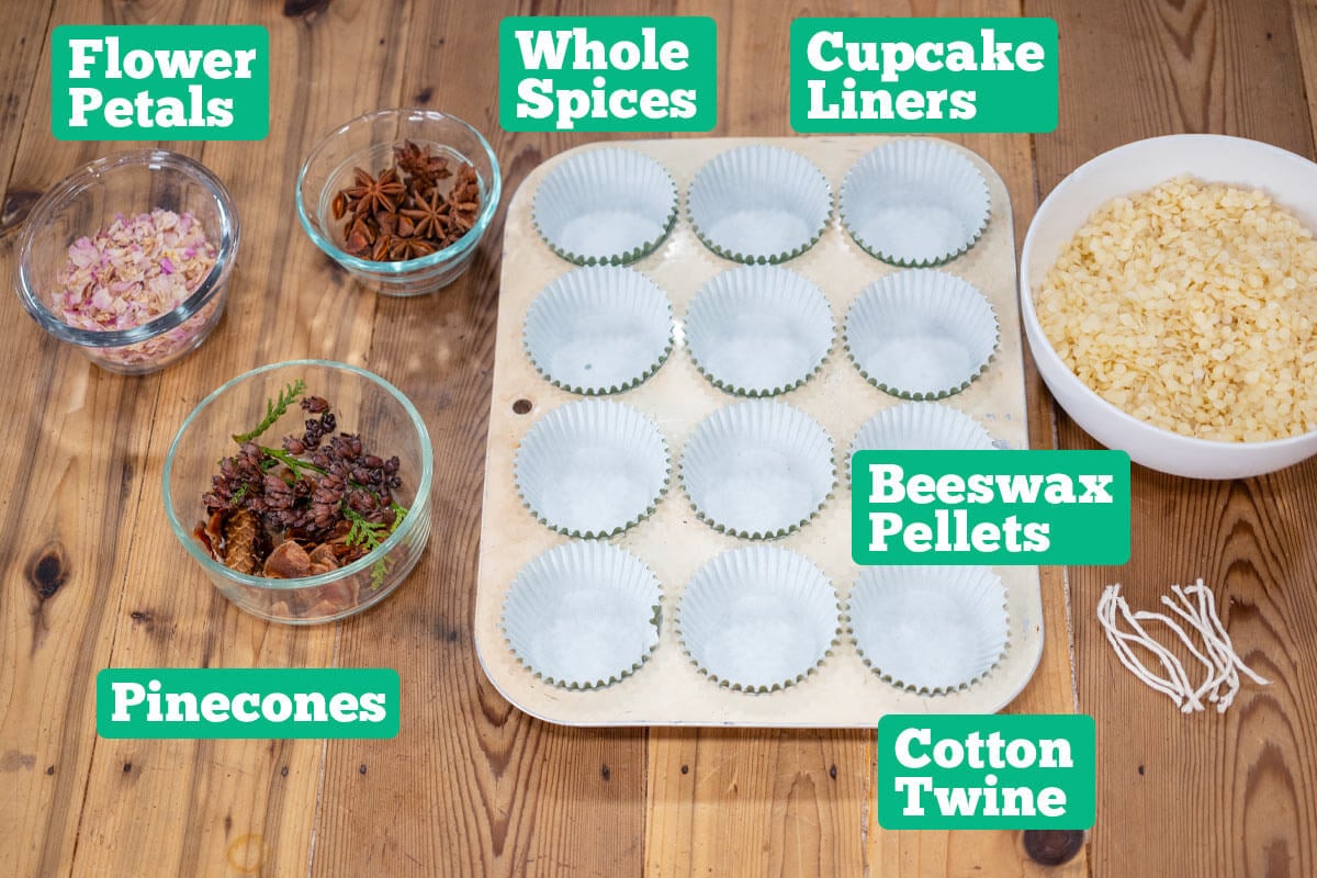 DIY Firestarter supplies: dried flower petals, whole spices, cupcake liners, muffin tin, beeswax pellets, cotton twine, and pinecones.