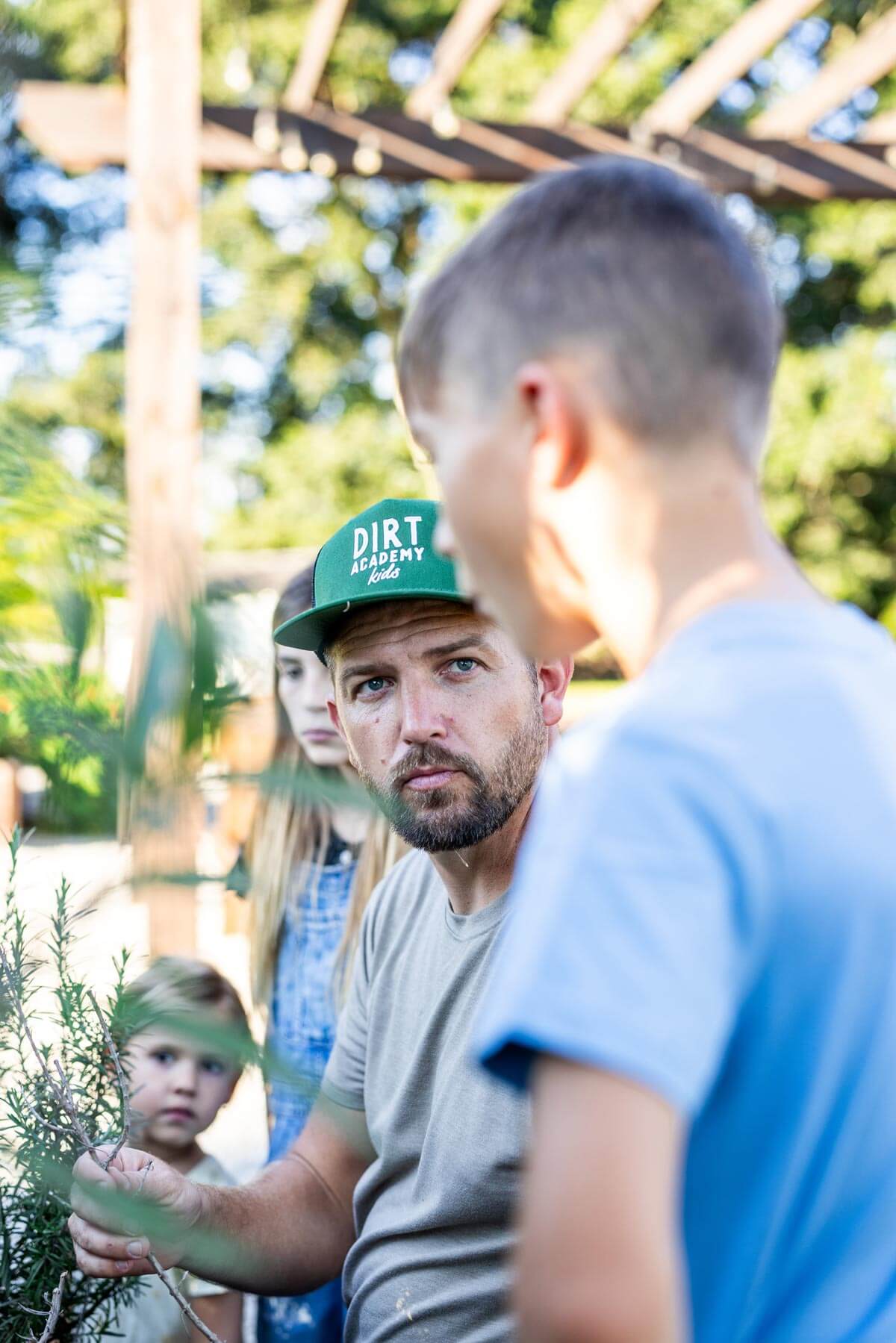 A man teaching children in the garden.