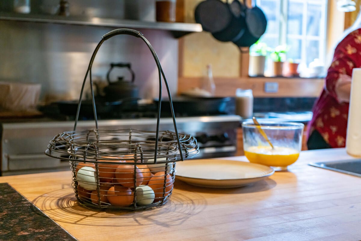 Eggs sitting on a kitchen counter in a basket.