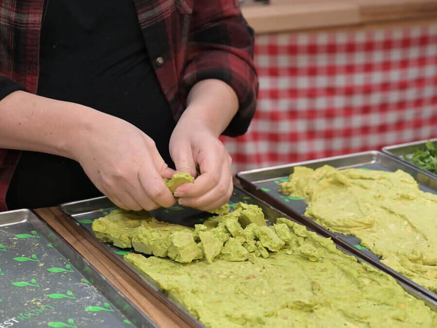 Freeze dried guacamole being crumbled.