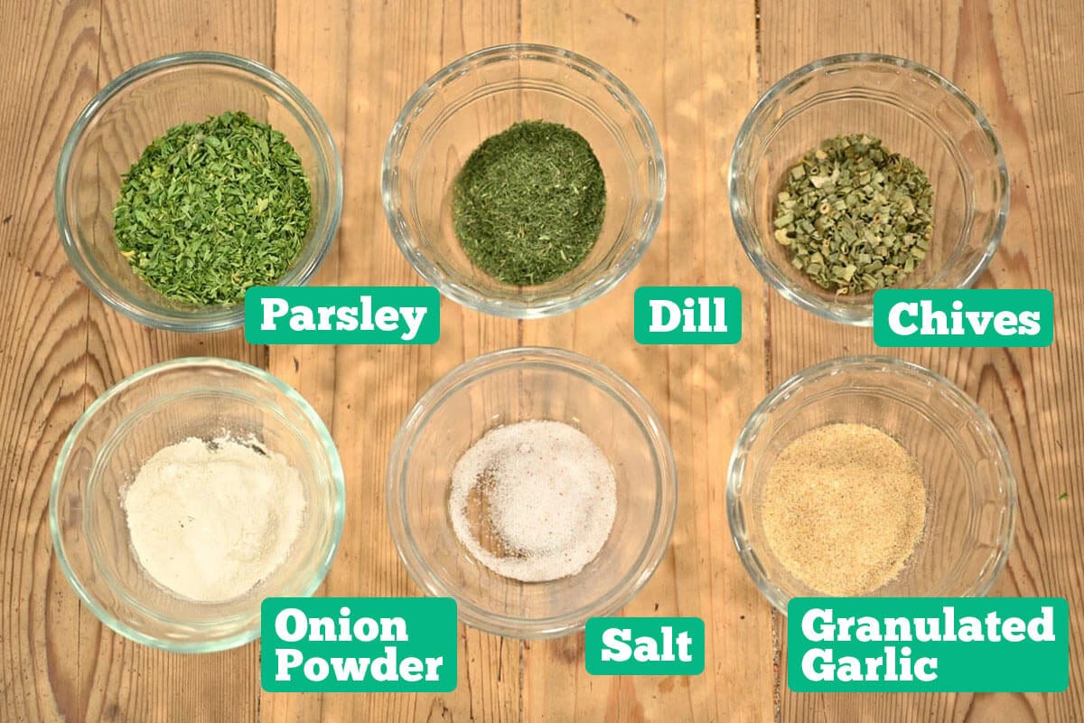 Homemade ranch seasoning mix ingredients: parsley, dill, chives, onion powder, salt, and garlic powder.