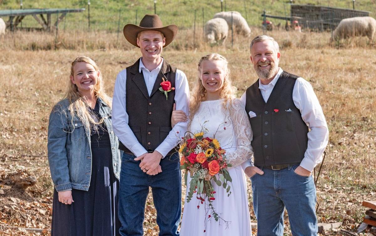 A husband, wife and parents on their wedding day.