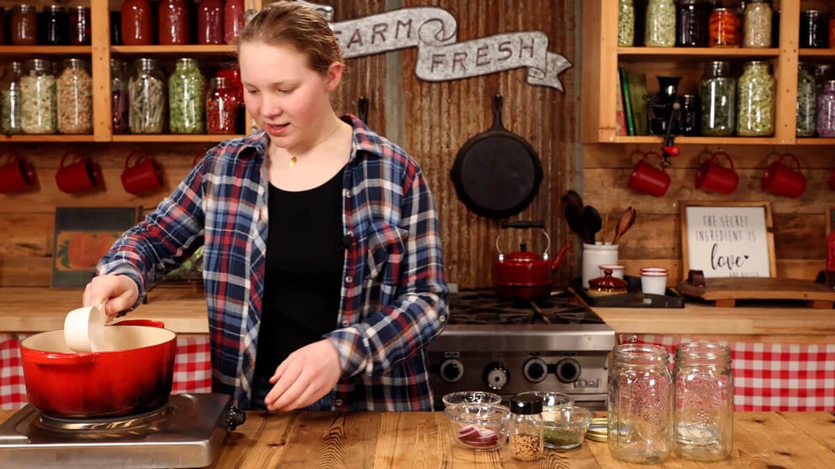 A girl making a vinegar brine for pickled eggs.