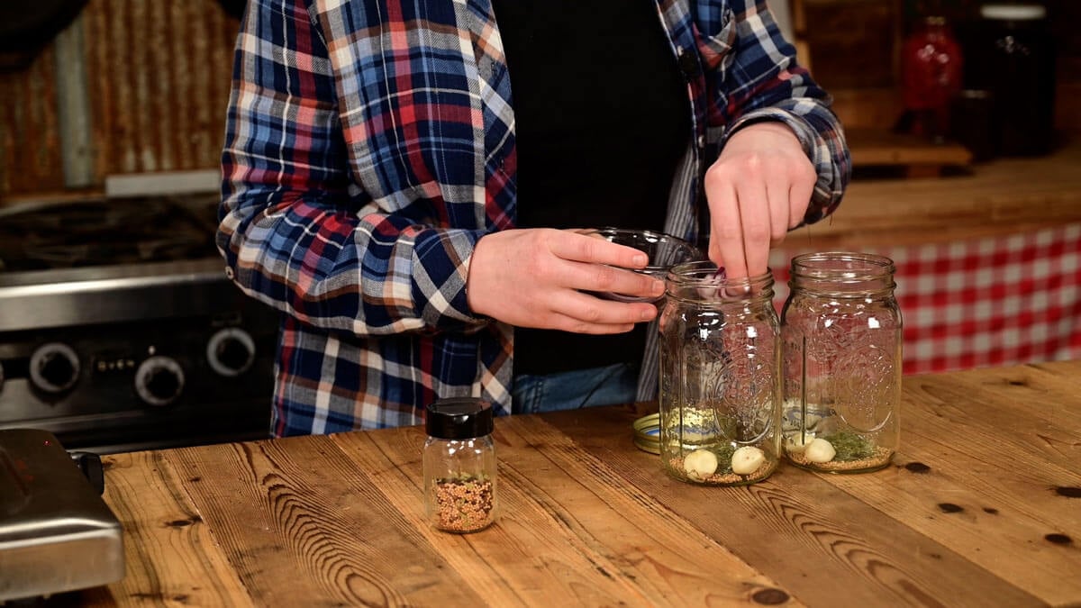 Herbs and spices going into Mason jars for pickled eggs.
