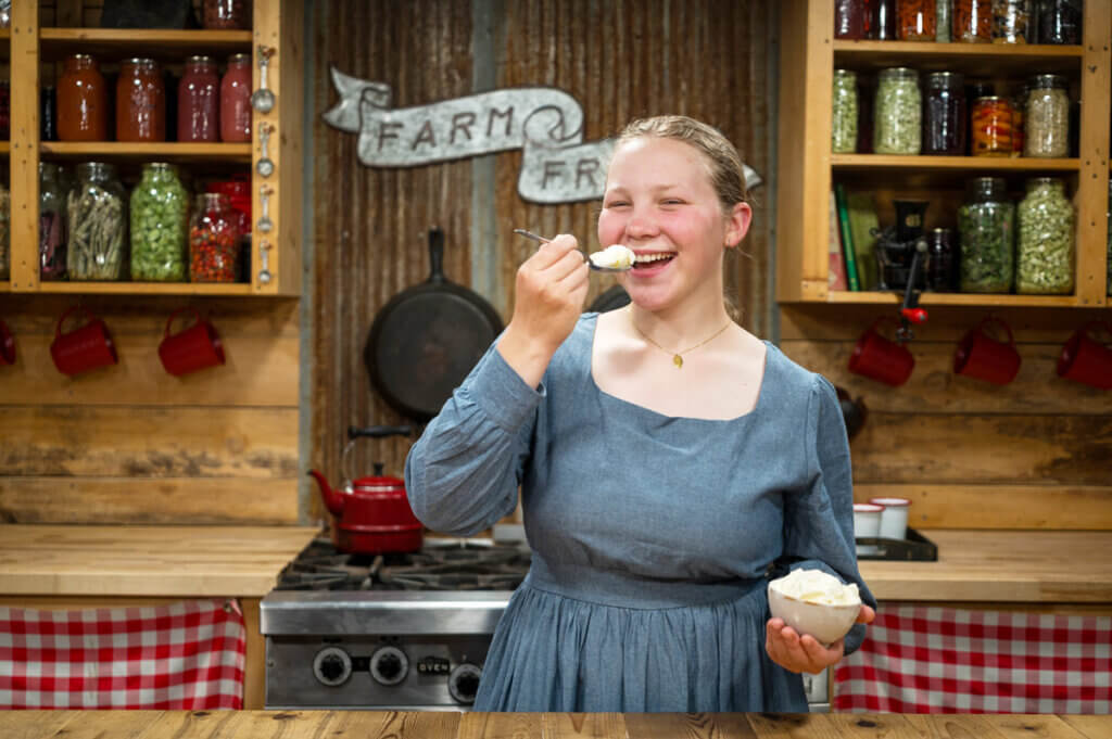 A young girl eating a bite of ice cream.