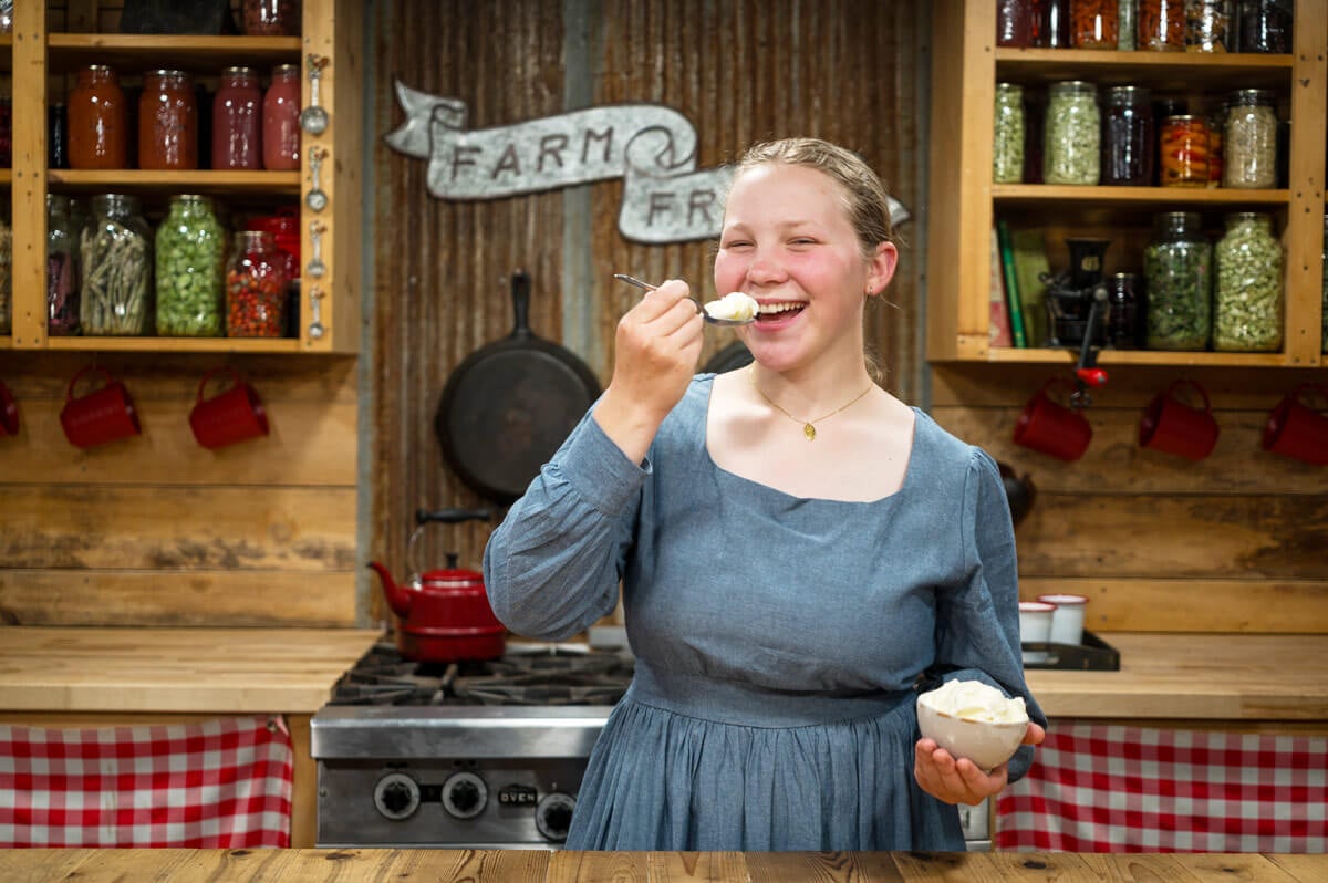 A young girl eating a bite of ice cream.