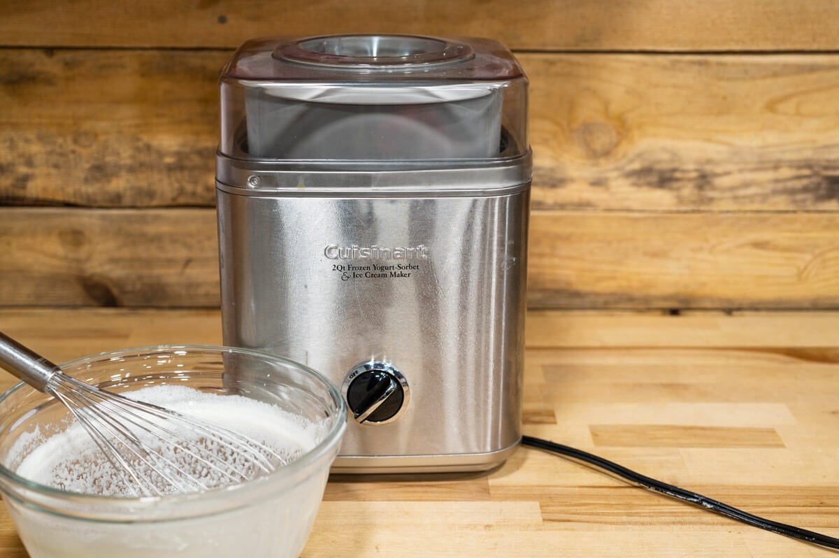 An ice cream maker with a bowl of ice cream mixture.