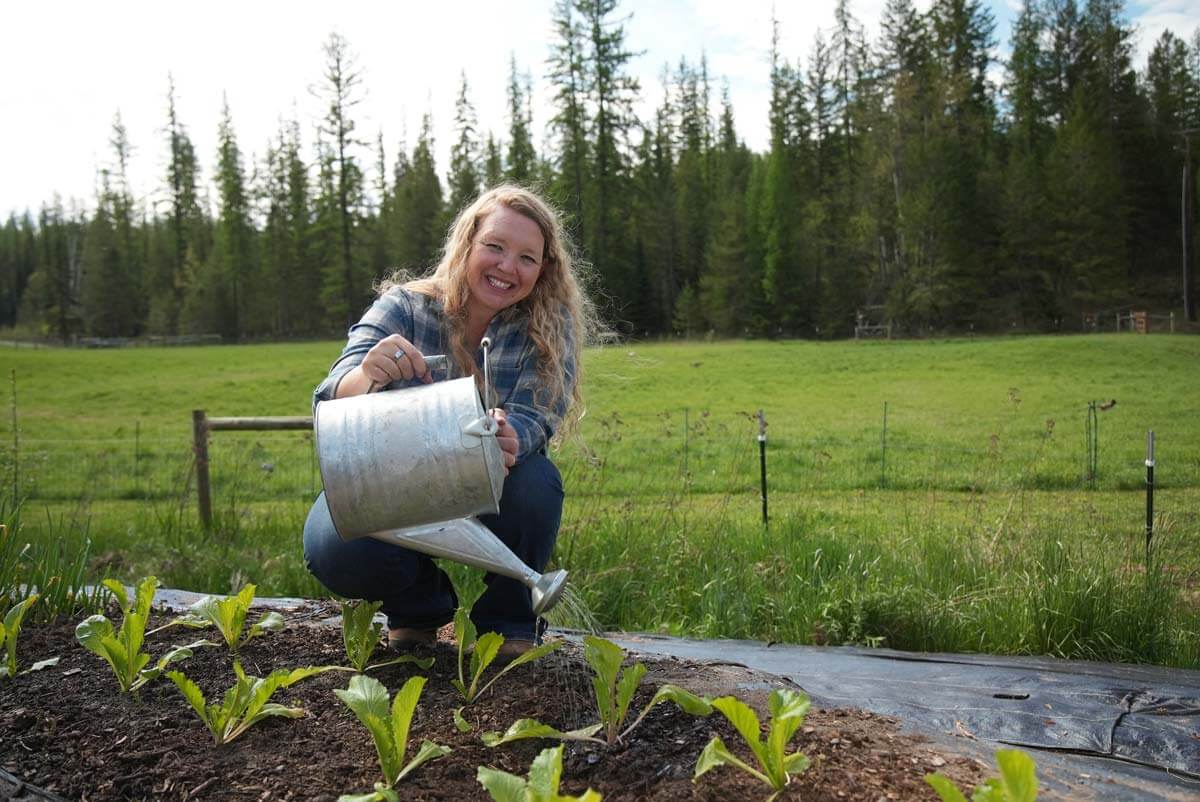 A woman watering a garden.