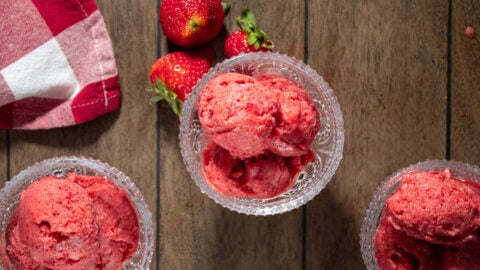 A bird's eye view of three serving dishes filled with strawberry sorbet.