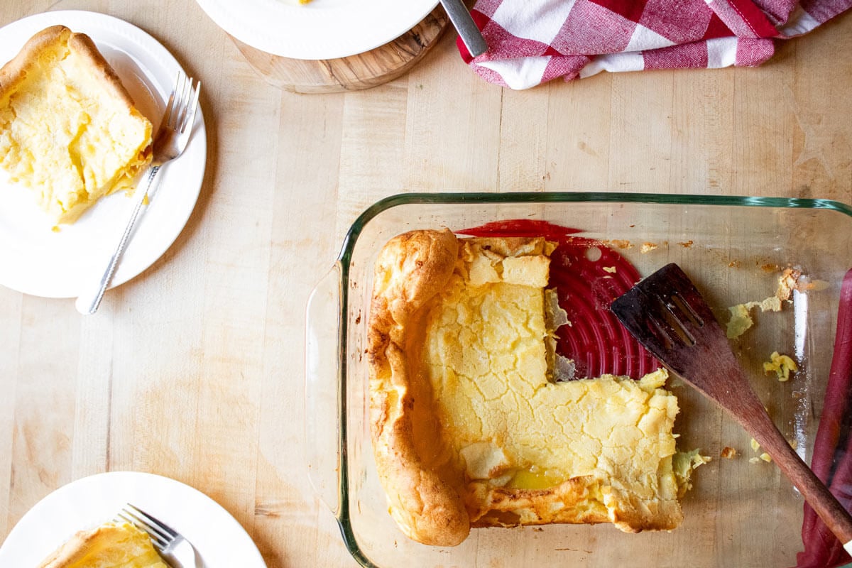 Bird's eye view of a German pancake in a baking dish with servings missing.