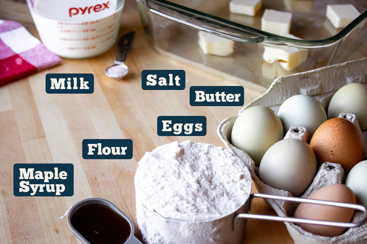 Easy German pancake recipe ingredients: milk, salt, butter, eggs, flour, vanilla, and maple syrup.