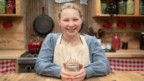A young girl with a jar of homemade sugar scrub.