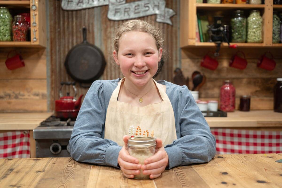 A young girl with a jar of homemade sugar scrub.