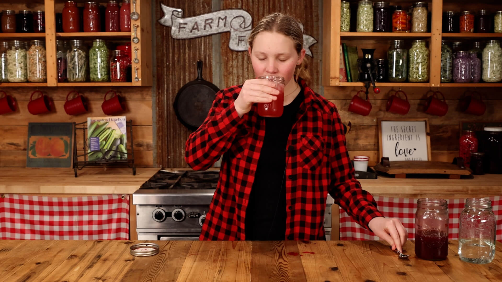 A young girl drinking a blackberry shrub soda.
