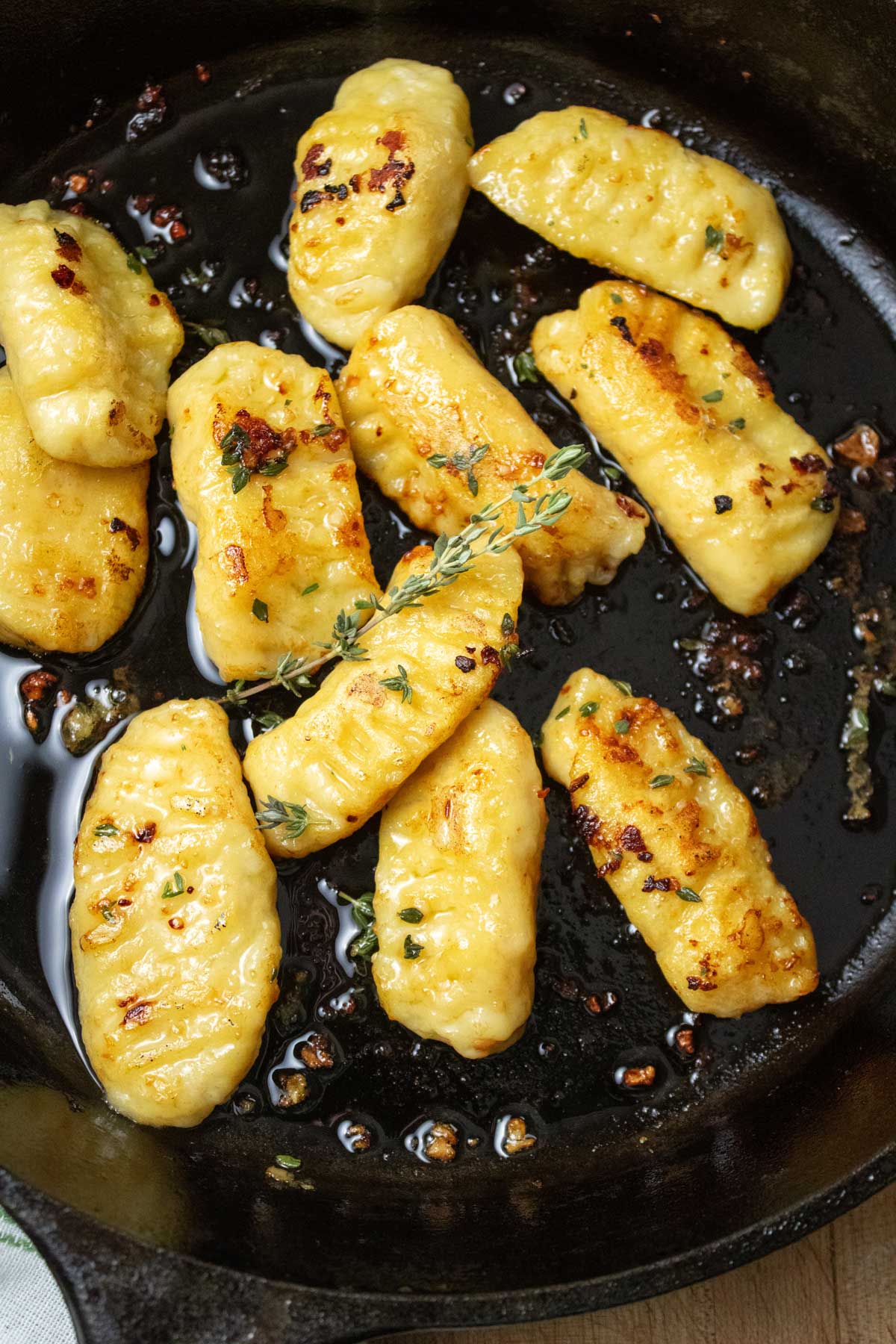 Bird's eye view of gnocchi sauteing in a cast iron pan.