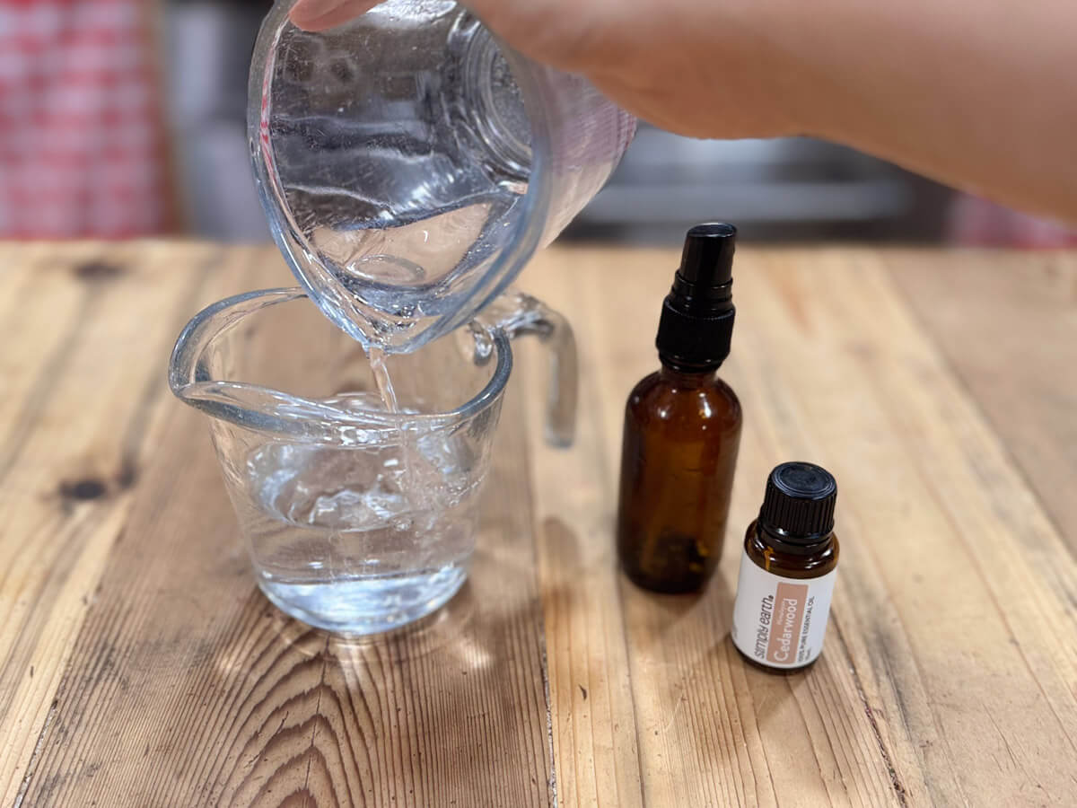 Pouring witch hazel into a measuring cup.