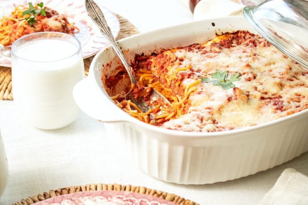 A white casserole dish full of baked spaghetti.