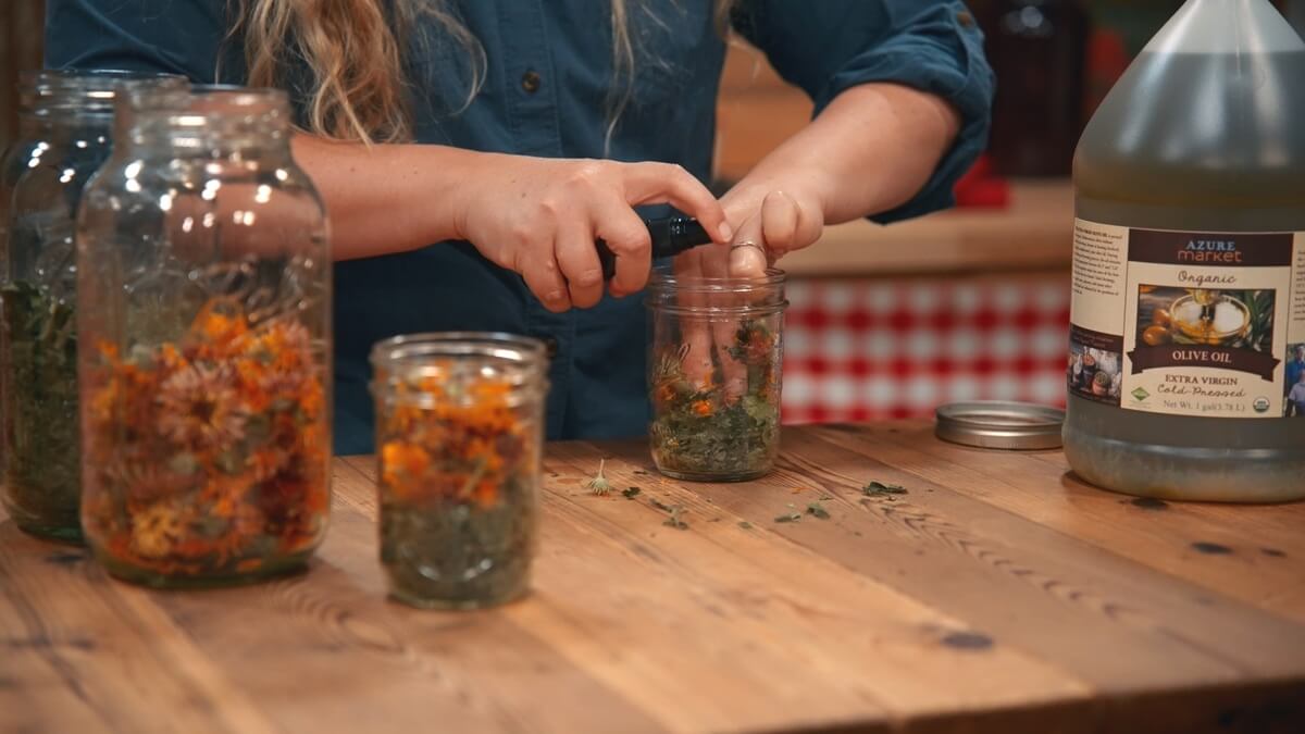 A woman spraying alcohol onto dried herbs.