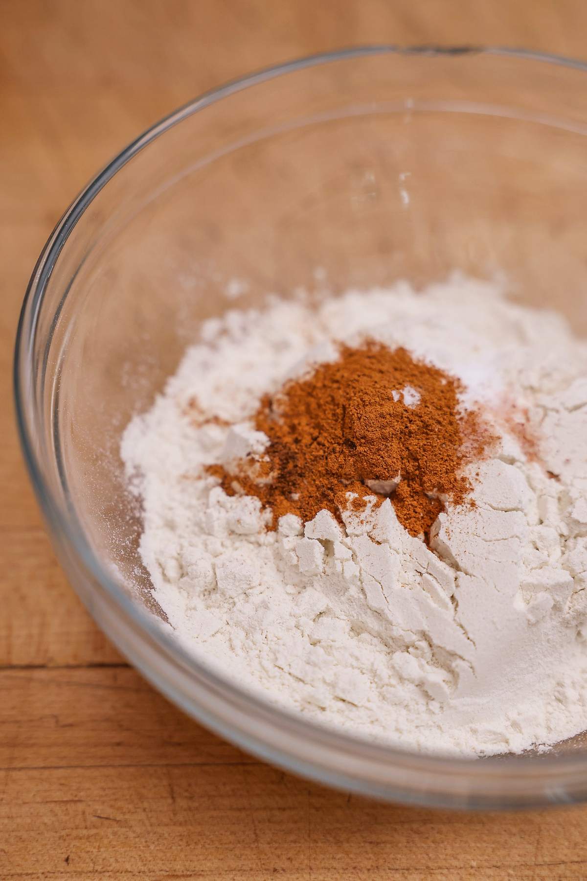 Flour and ground spices in a glass mixing bowl.