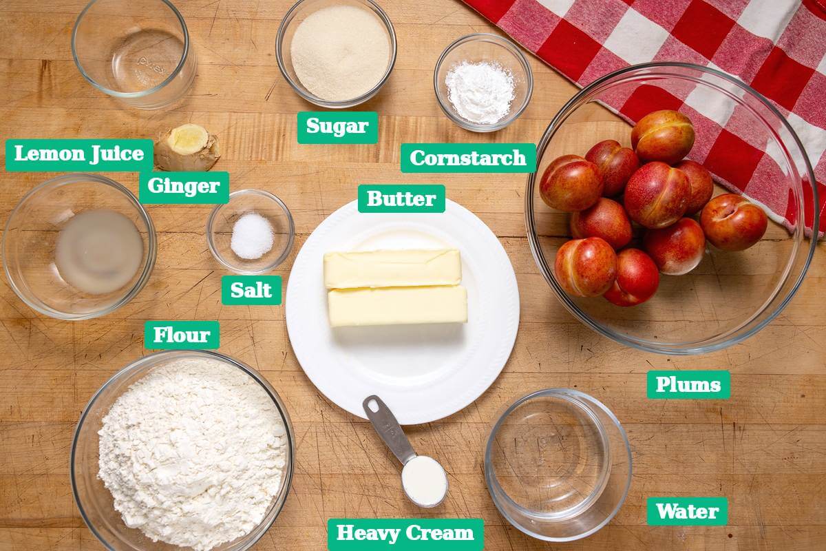 Ingredients for plum hand held pies arranged on a wooden counter.