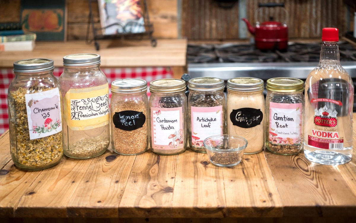 Dried herbs for making digestive herbal bitters on a counter.