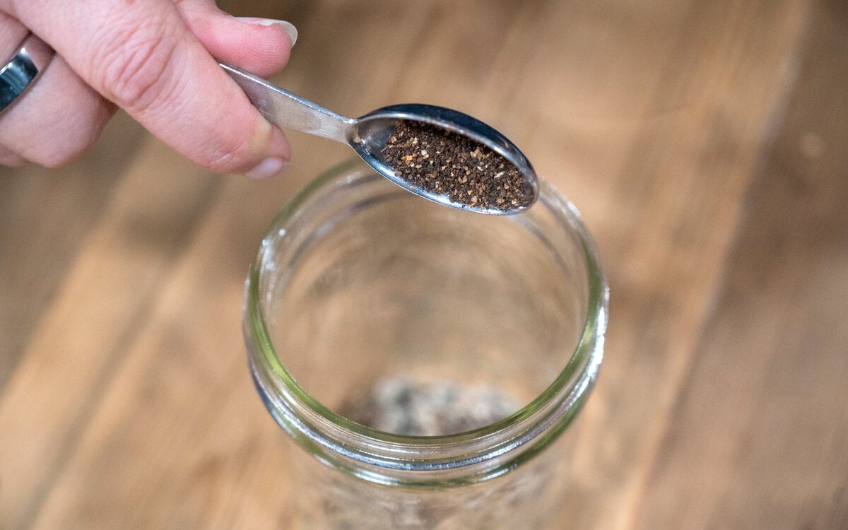Herbs being measured into a cup.