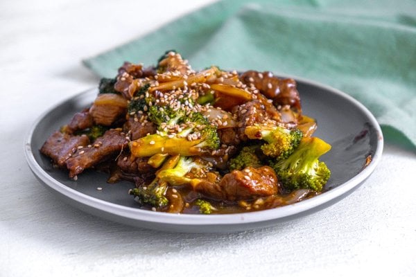 Beef and broccoli stir fry served on a gray plate.