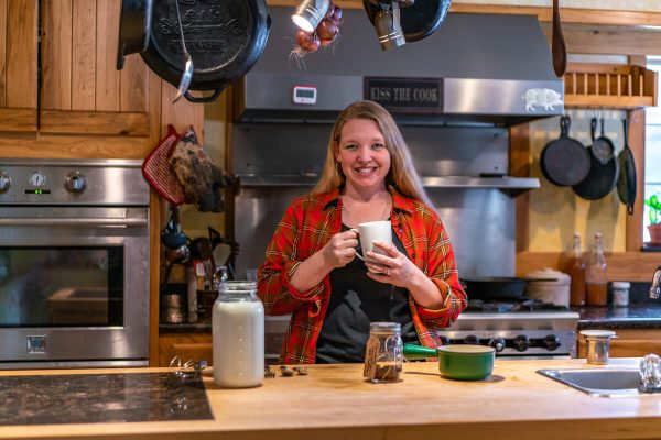 A woman in the kitchen holding a mug of tea.