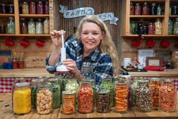 A woman vacuum sealing jars of freeze dried food.