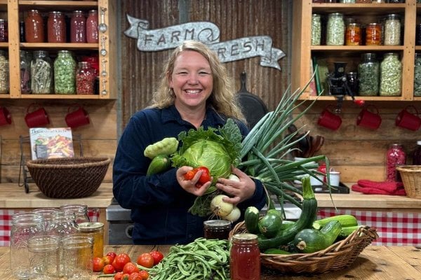 Carolyn_Harvest_Preserving_Produce A woman with an armful of produce in the kitchen.