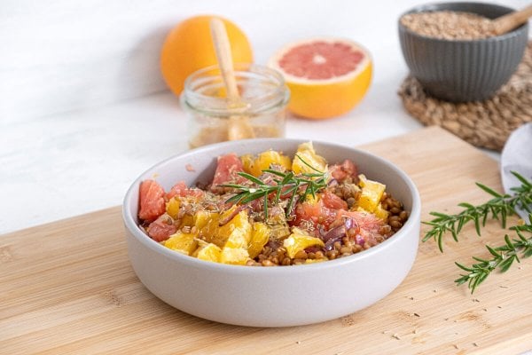 Citrus-Salad-Feature_HF Warm citrus salad served in a white bowl and garnished with a sprig of fresh rosemary.