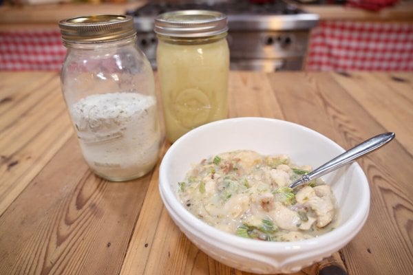 Cream of chicken soup in a white bowl on a wooden counter.