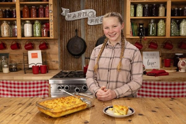 A girl standing in the kitchen with a French toast souffle recipe.