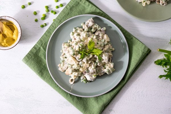 Frozen-Green-Pea-Salad-Hero_HF Frozen green pea salad served on a gray plate and garnished with parsley.