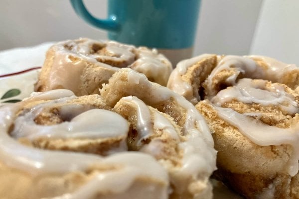 Gluten free cinnamon rolls, frosted on a plate.