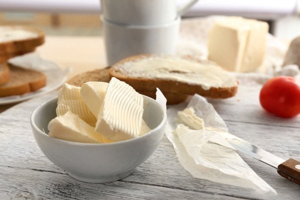 Slices of butter arranged in a white dish.