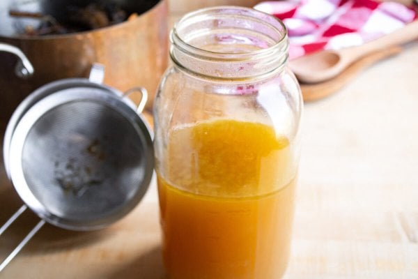 Homemade chicken bone broth in a mason jar.