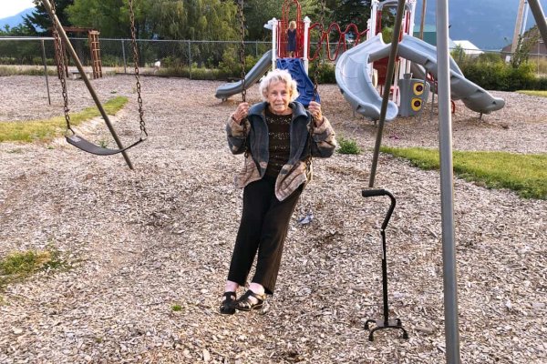 IMG_8353 Image of an elderly woman swinging on a swingset.