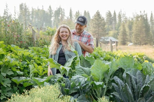 A man and woman standing in a garden.