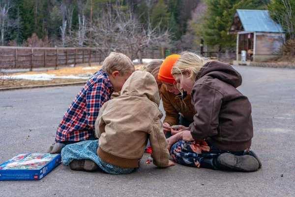 Kids huddled in a circle bundled up outside.