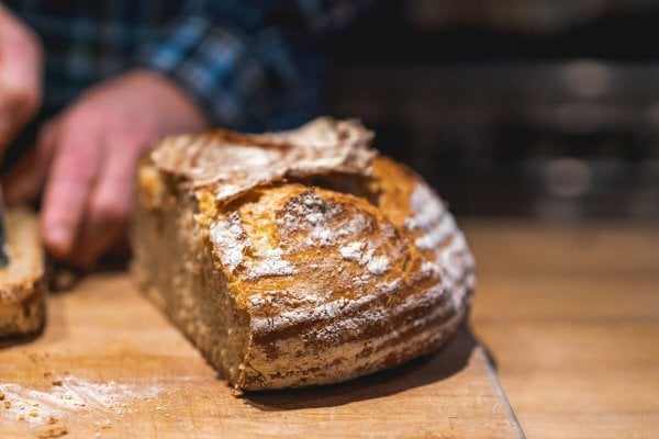 A loaf of sourdough bread being sliced.